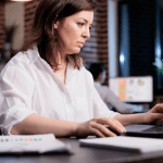 A legal lead generation specialist reviewing digital campaign analytics under time pressure in a fast-paced office environment
