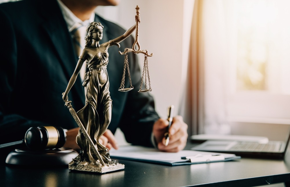Lady Justice statue on lawyer’s desk during client consultation