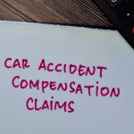 Clipboard with text reading “Car Accident Compensation Claims” beside a calculator