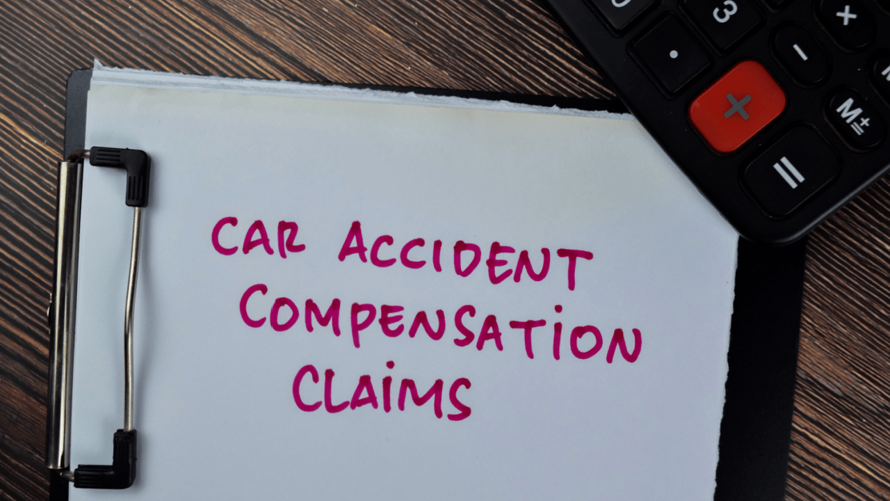 Clipboard with text reading “Car Accident Compensation Claims” beside a calculator
