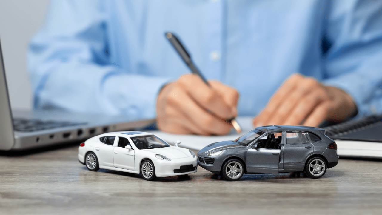 Miniature cars and person writing on clipboard — how to get car accident leads concept