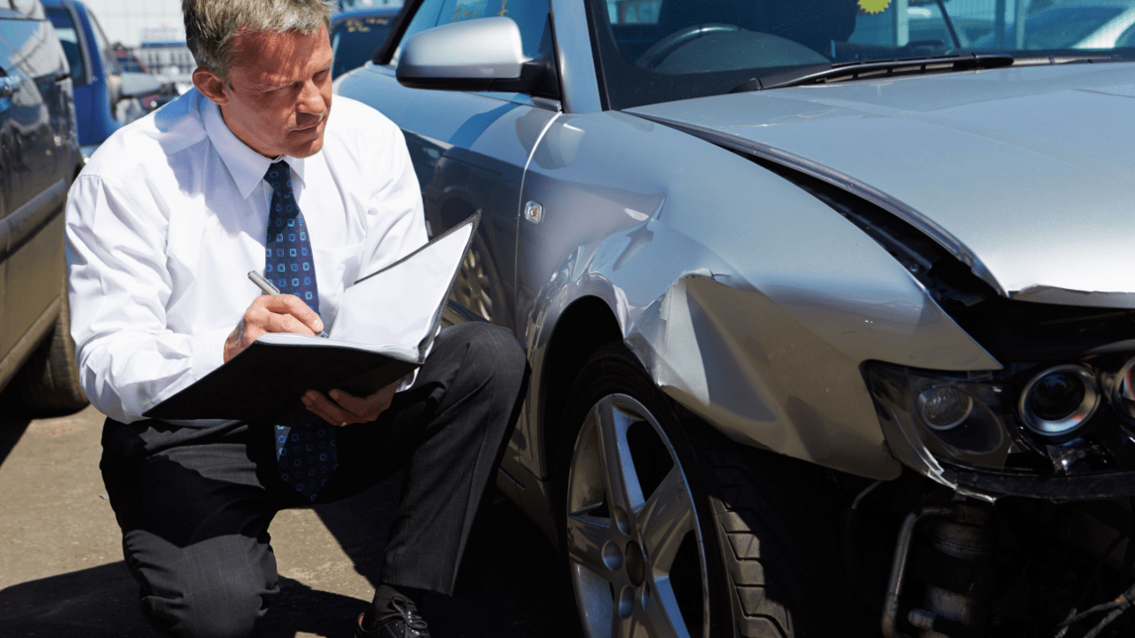 Insurance adjuster inspecting damaged car after accident – what happens if you get insurance after an accident