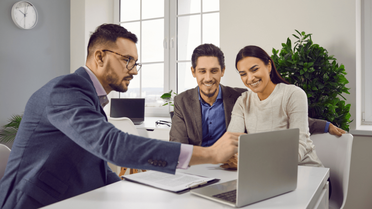 Financial advisor discussing bankruptcy options with a smiling couple during a consultation.