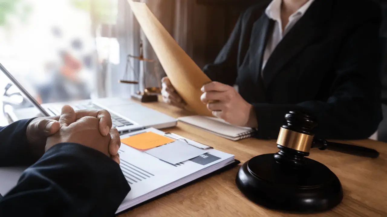 Client meeting with California bankruptcy lawyer to discuss Chapter 7 fees, showing legal documents, gavel, and consultation setup