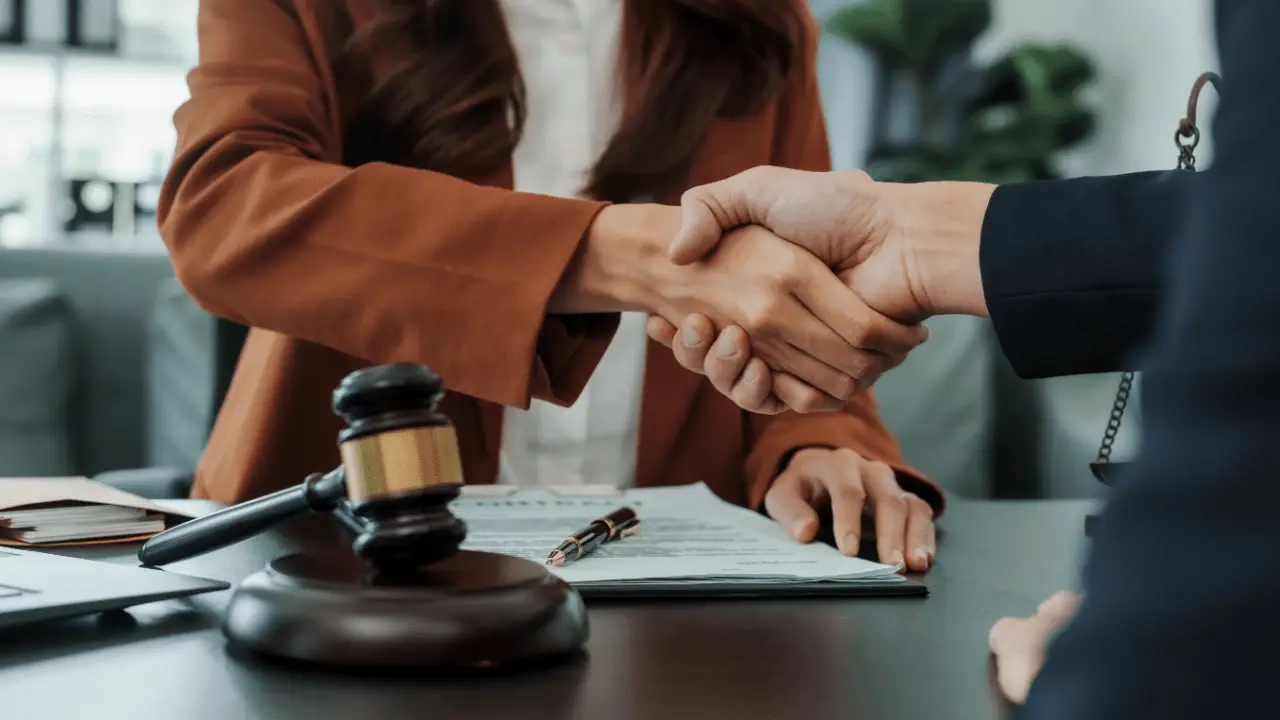 Bankruptcy attorney shaking hands with new client after successful consultation, demonstrating effective strategies on how to find bankruptcy clients