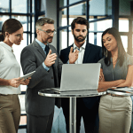 Legal team strategizing around a laptop in a modern office — how to market a criminal law practice and how hard is it to be a criminal defense lawyer.