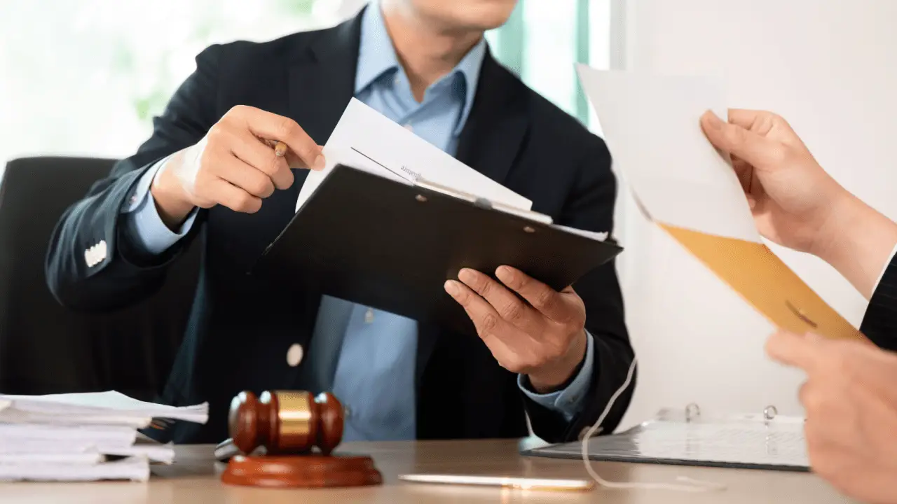 Attorney reviewing case documents with client showing benefits when law firms buy auto accident leads