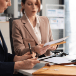 Two female attorneys collaborating on auto accident lead generation strategy while reviewing case documents in modern law office