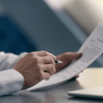 Man reviewing financial documents at a desk, weighing whether is it better to file bankruptcy or just not pay.