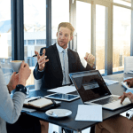 Law firm partners discussing how much does law firm SEO cost during strategy meeting with laptop and documents