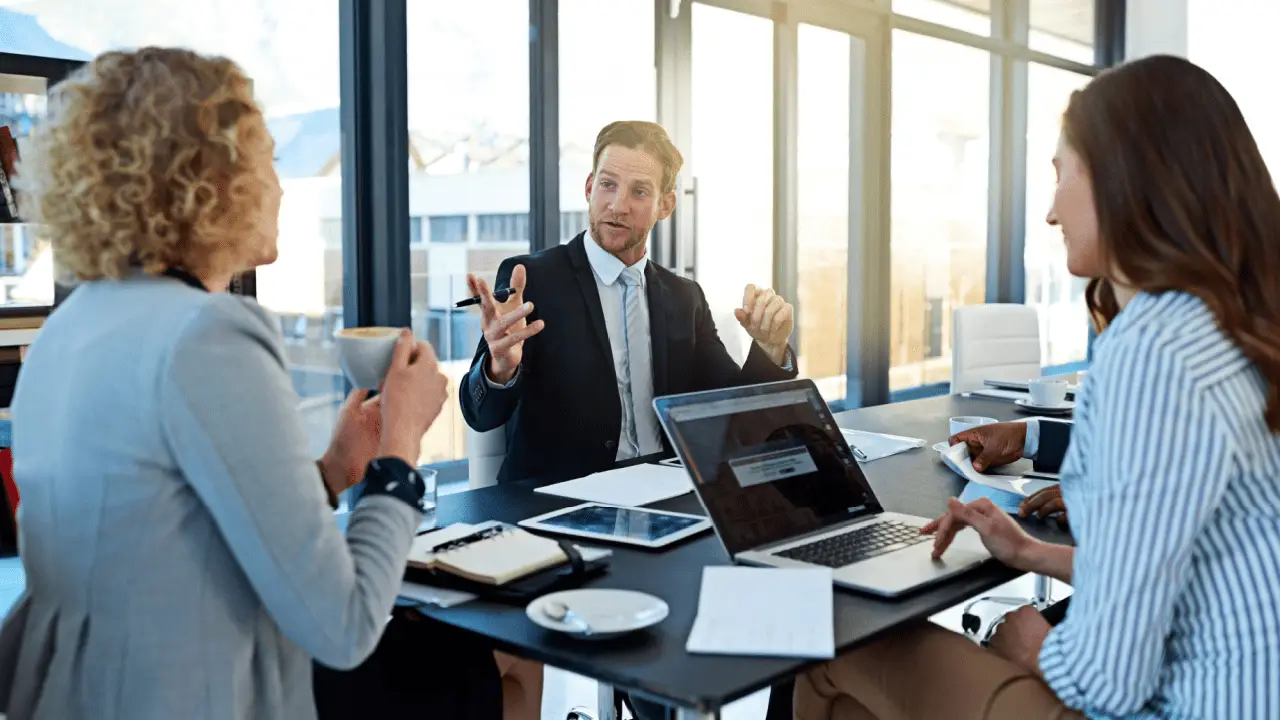 Law firm partners discussing how much does law firm SEO cost during strategy meeting with laptop and documents