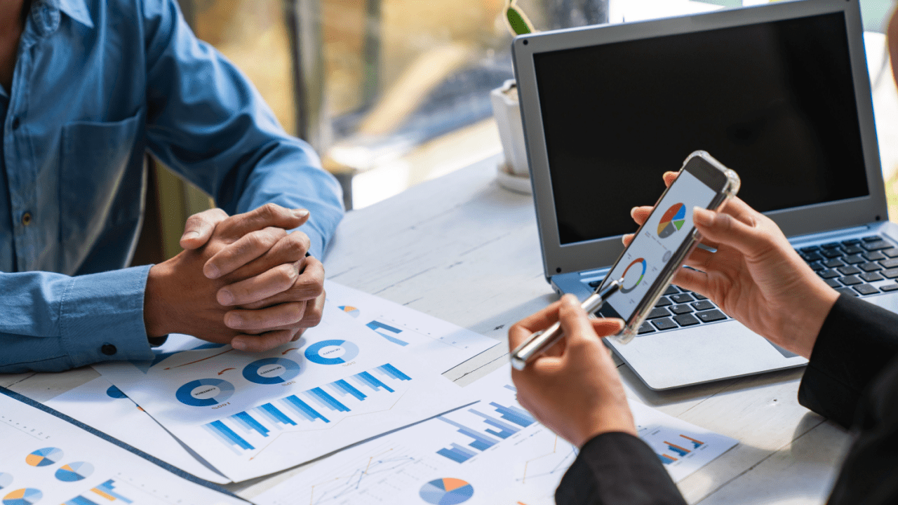 Business consultants reviewing analytics charts and smartphone data showing how to measure ROI from law firm SEO campaigns