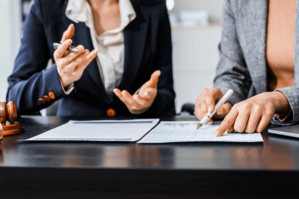 Two attorneys discussing what is the role of backlinks in law firm SEO while reviewing analytics and documents with gavel on desk