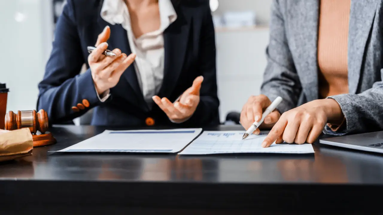 Two attorneys discussing what is the role of backlinks in law firm SEO while reviewing analytics and documents with gavel on desk