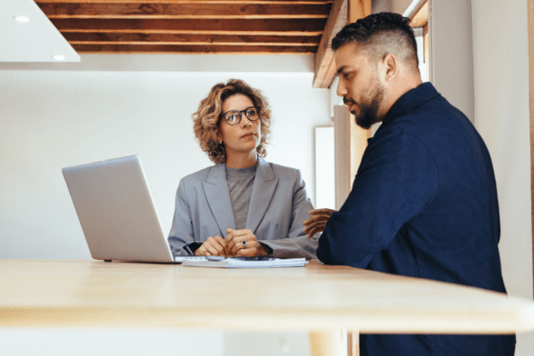 Marketing consultant teaching attorney how to generate bankruptcy leads using laptop in modern office