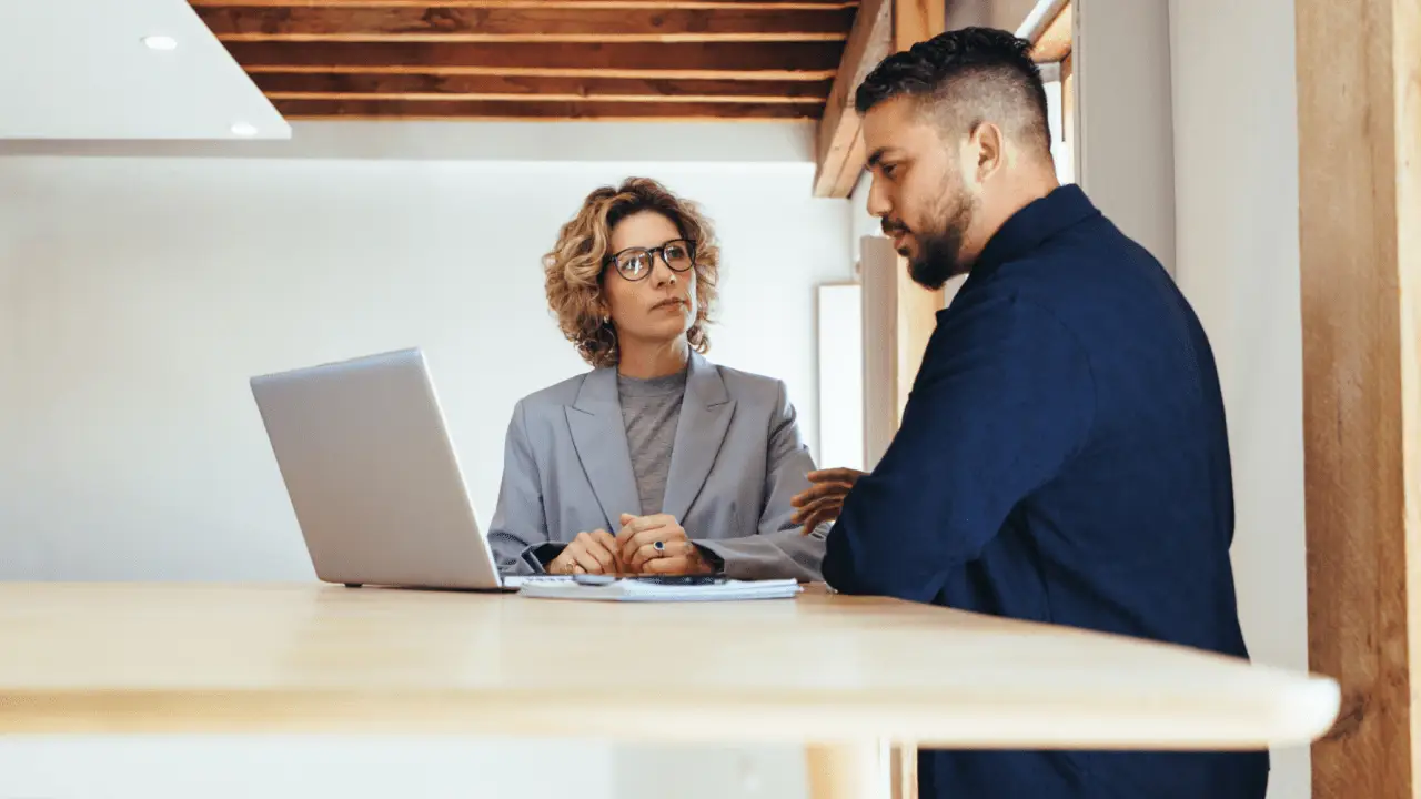 Marketing consultant teaching attorney how to generate bankruptcy leads using laptop in modern office
