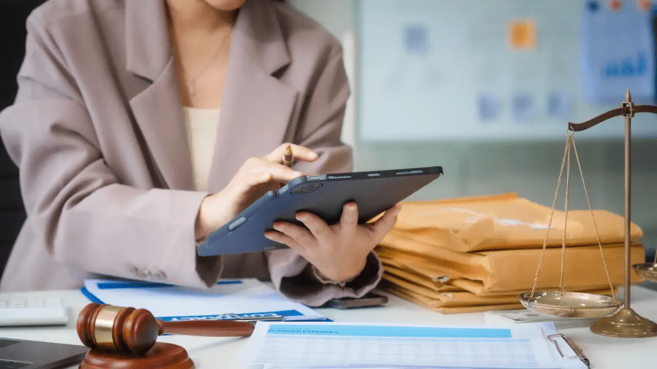 Law firm SEO professional using tablet to optimize legal website with gavel and legal documents on desk