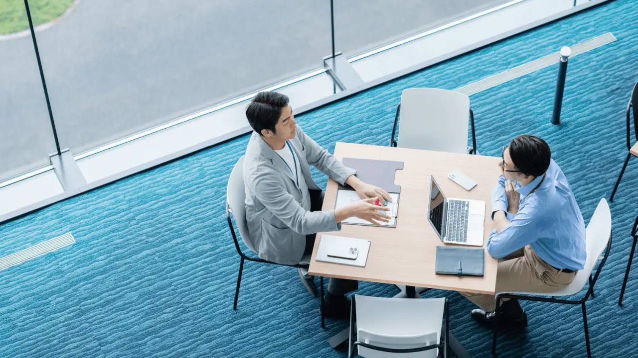 Two business professionals collaborating on marketing strategies for bankruptcy lawyers in modern office space