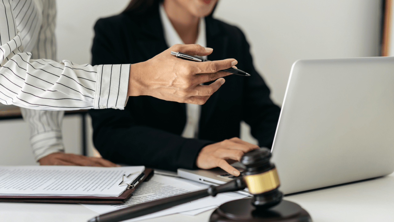 Law firm professionals discussing if AI intake automation is worth it with laptop and legal documents