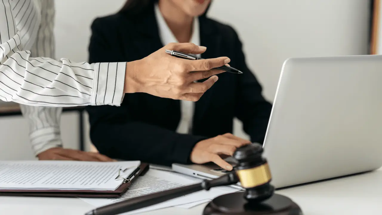 Law firm professionals discussing if AI intake automation is worth it with laptop and legal documents