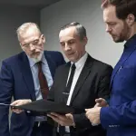 Three attorneys reviewing sustainable law firm lead generation analytics and marketing performance data on tablet