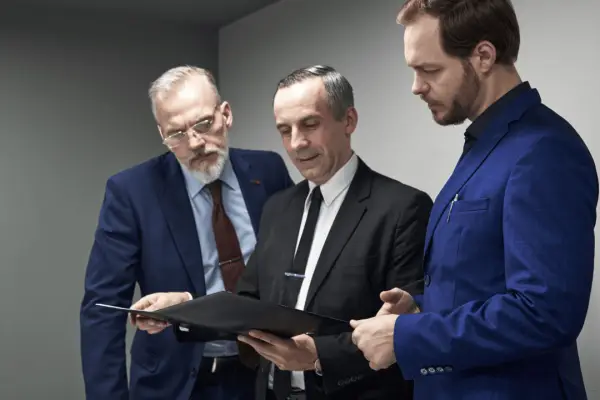 Three attorneys reviewing sustainable law firm lead generation analytics and marketing performance data on tablet