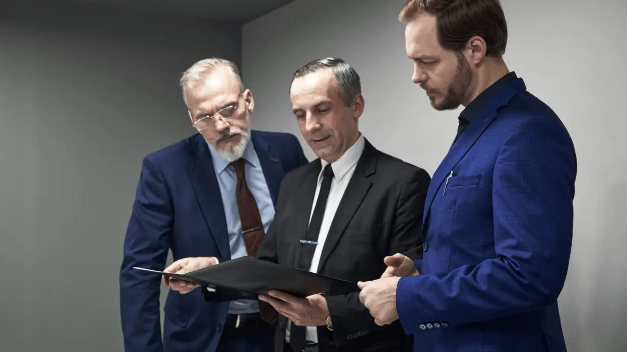 Three attorneys reviewing sustainable law firm lead generation analytics and marketing performance data on tablet