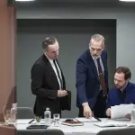 Law firm intake optimization meeting with attorneys reviewing client consultation documents in modern conference room