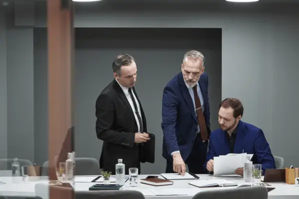 Law firm intake optimization meeting with attorneys reviewing client consultation documents in modern conference room