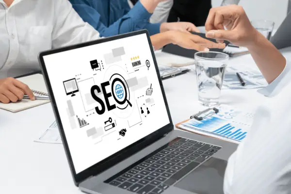 Legal SEO authority building team meeting with laptop showing SEO strategy, analytics charts, and digital marketing icons