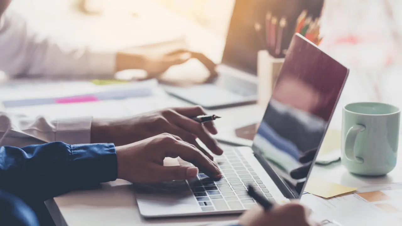 Technical SEO for law firms workspace with professionals typing on laptops surrounded by documents, coffee, and office supplies