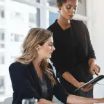 Two attorneys implementing blog strategy for legal SEO at modern law firm office