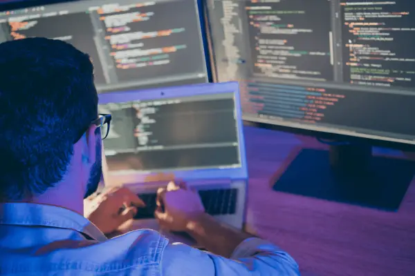 Attorney reviewing long-term legal SEO strategy implementation code on multiple computer monitors