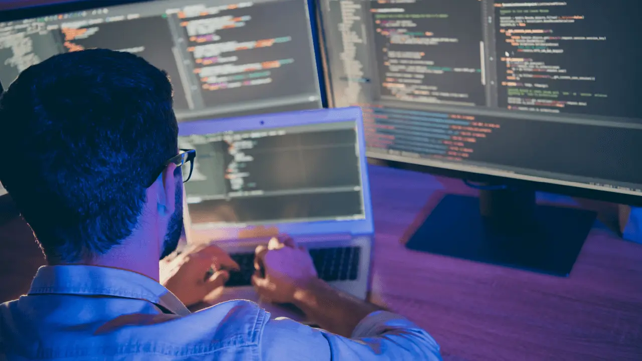 Attorney reviewing long-term legal SEO strategy implementation code on multiple computer monitors